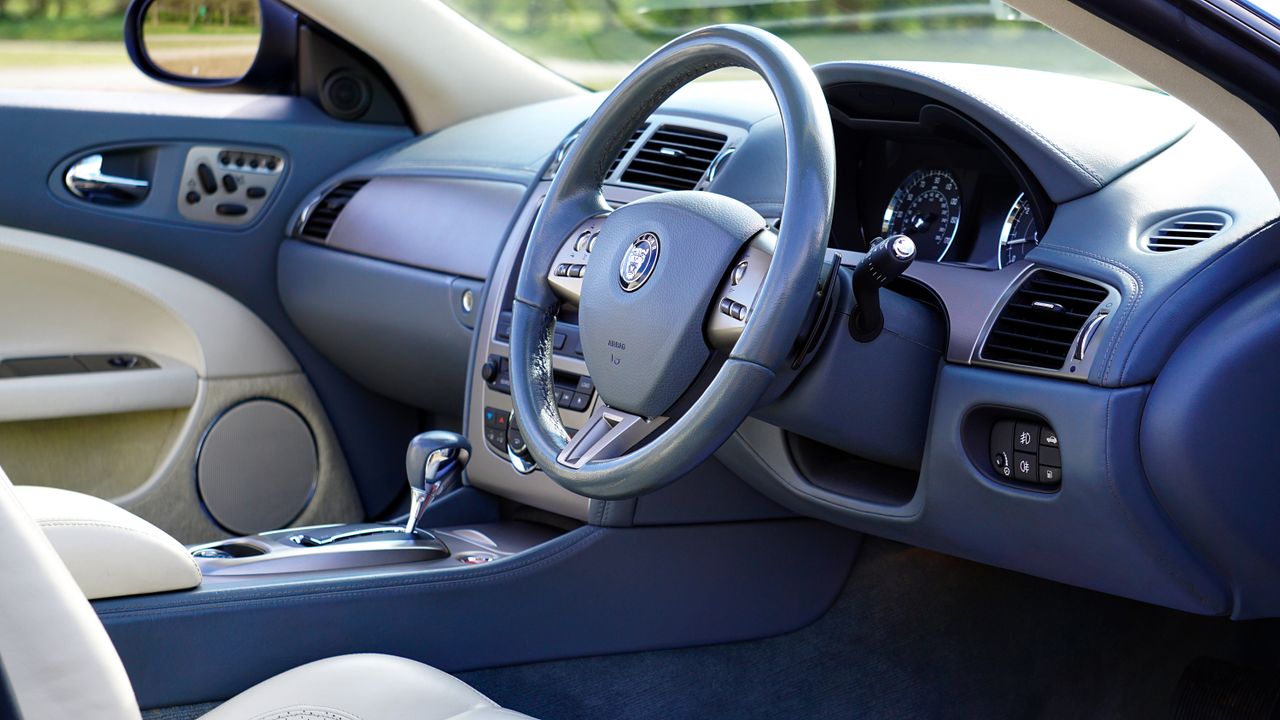 services-04 Elegant interior of luxury car featuring steering wheel and dashboard.